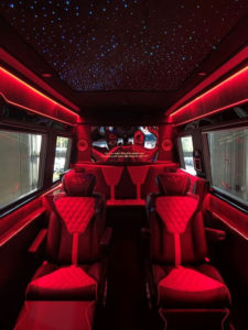 Red LED-lit van conversion interior with fiber-optic starlight ceiling and diamond-quilted captain chairs
