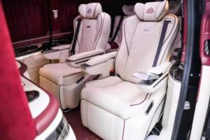 Cream Mercedes-Maybach captain chairs with burgundy leather accents in a custom van conversion