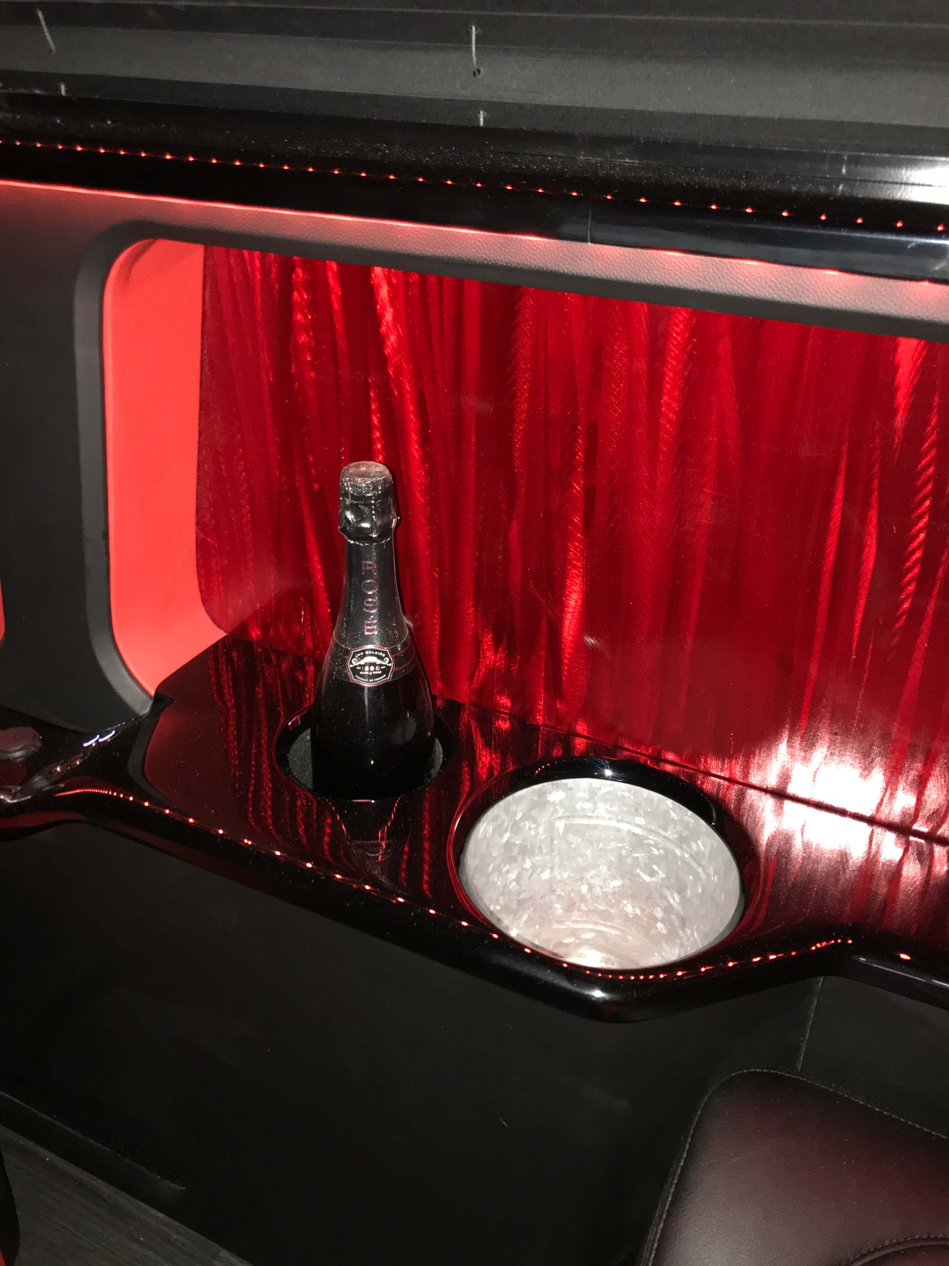 Custom-fabricated champagne bar console with integrated cupholder in a van conversion