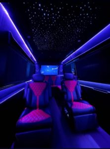 Purple LED-lit van conversion interior with magenta diamond-quilted captain chairs and starlight ceiling