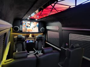 Custom van conversion cabin with blue accent lighting and quilted seating