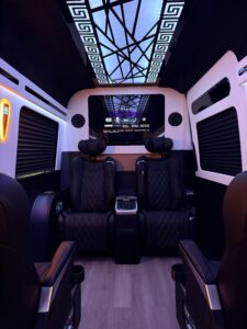 Custom van conversion interior with dramatic geometric ceiling panel and blue ambient lighting