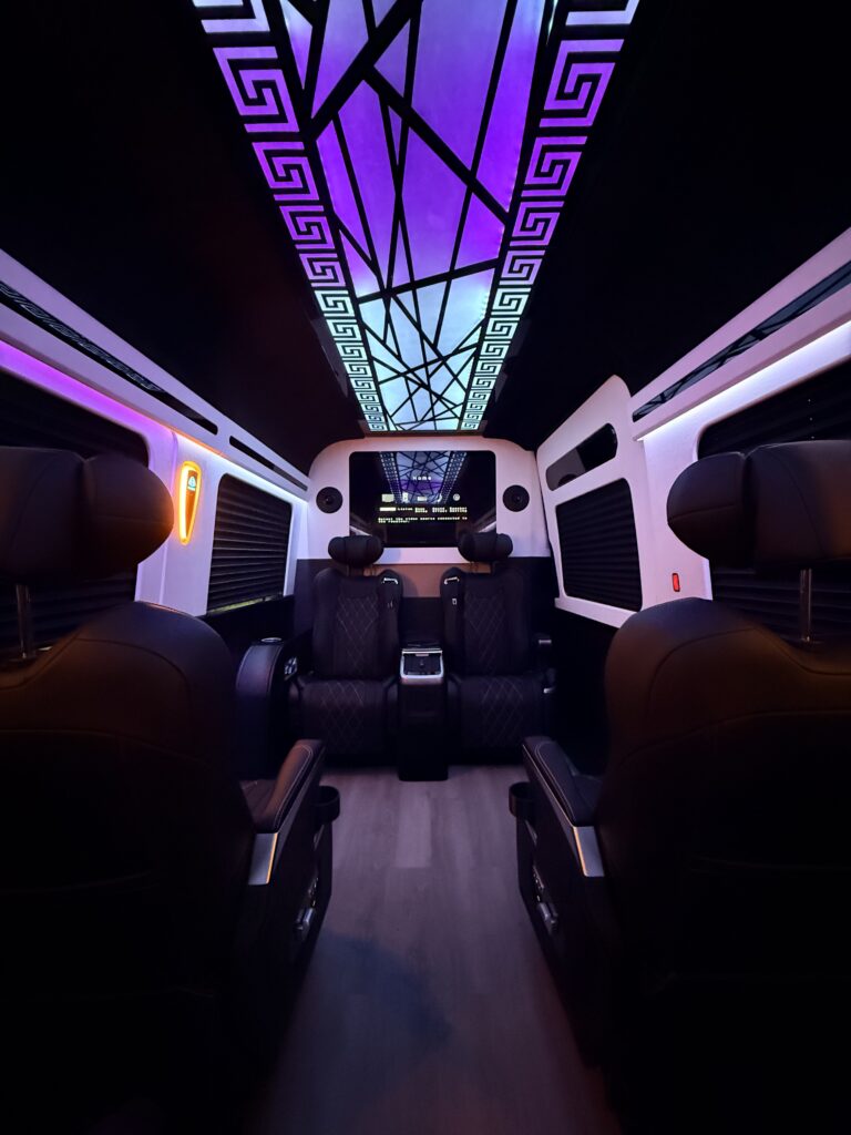 Custom van conversion interior showcasing captain chairs and ambient cabin lighting