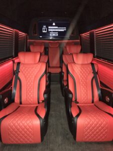 Custom van conversion cabin with quilted leather seating and ambient lighting