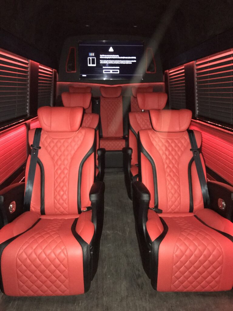 Custom van conversion cabin with quilted leather seating and ambient lighting