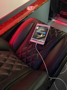 Red diamond-quilted seat with mounted entertainment tablet, custom fabrication detail