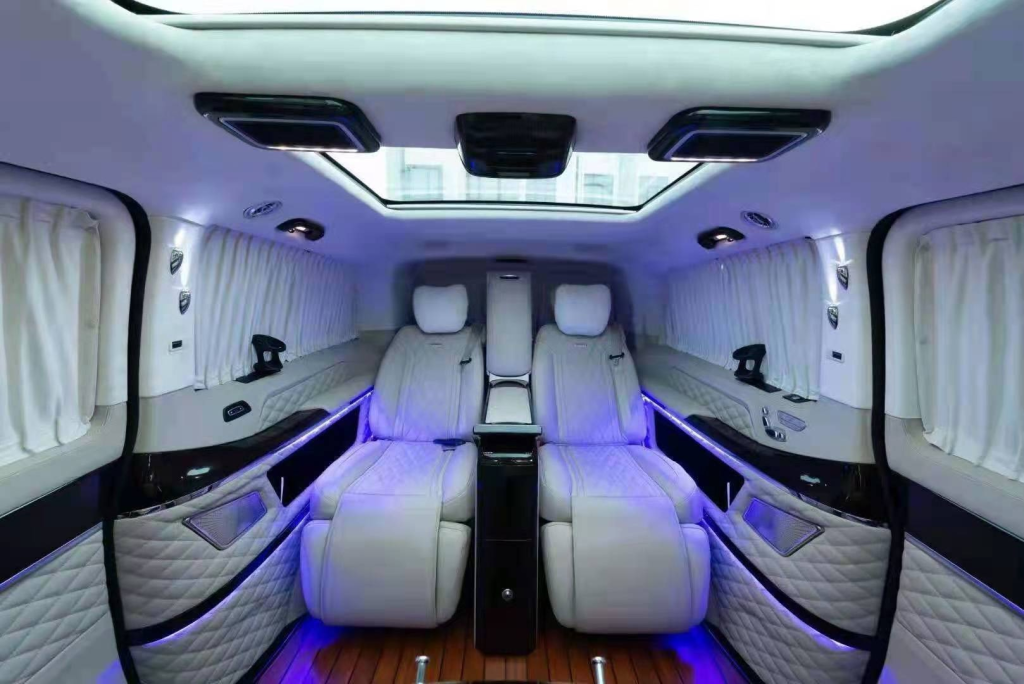 White captain chairs in a van conversion with panoramic skylight windows